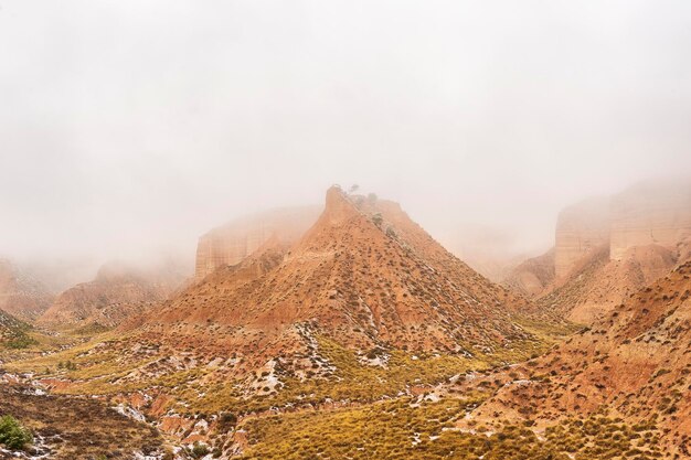 갈색 산이 부분적으로 눈으로 덮인 사막.
