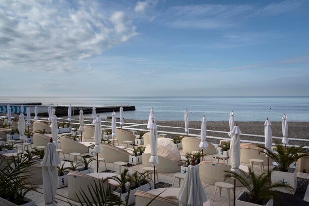 A deserted beach on the coast of Sochi with sun beds and umbrellas against the background of the calm Black Sea Adler Krasnodar Territory Russia