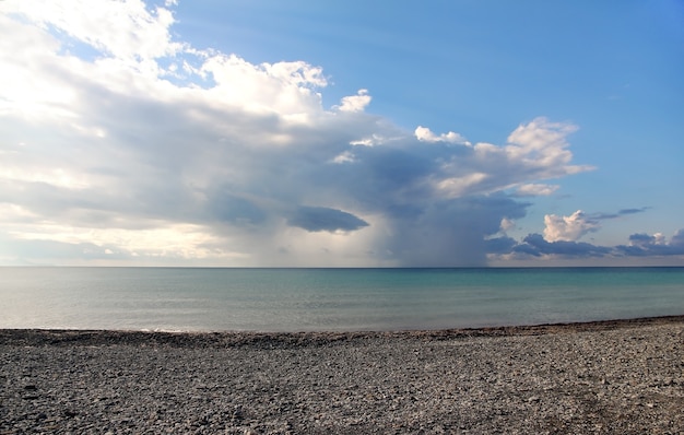 Deserted stony of sea shore against background of clouds