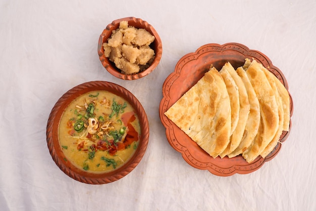 Desi breakfast haleem halim dhaleem halwa and paratha served in dish isolated on background top view of bangladesi breakfast