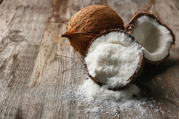 Desiccated coconut in nut on wooden table