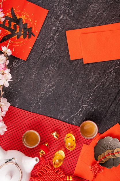中国の太陰暦の1月の新年のデザインコンセプト-お祝いのアクセサリー、赤い封筒（ang pow、hong bao）、上面図、フラットレイ、頭上。 「チュン」という言葉は、春が来ることを意味します。