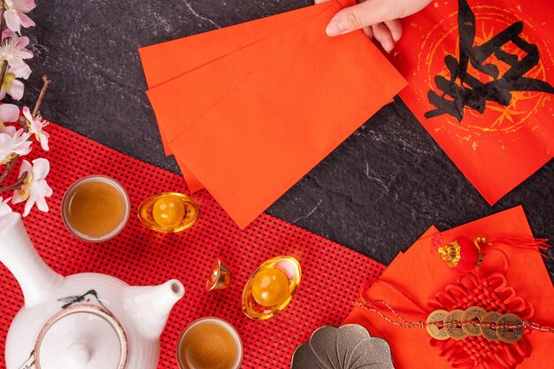 Design concept of Chinese lunar January new year - Woman holding, giving red envelopes (ang pow, hong bao) for lucky money, top view, flat lay, overhead above. The word 'chun' means coming spring.