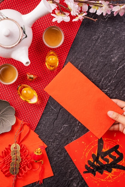 Design concept of Chinese lunar January new year Woman holding giving red envelopes ang pow hong bao for lucky money top view flat lay overhead above The word 'chun' means coming spring