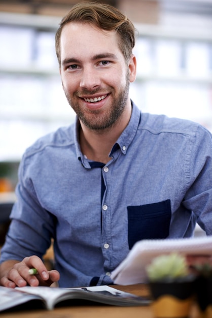 Photo design is his passion portrait of a handsome young man paging through a magazine in the office