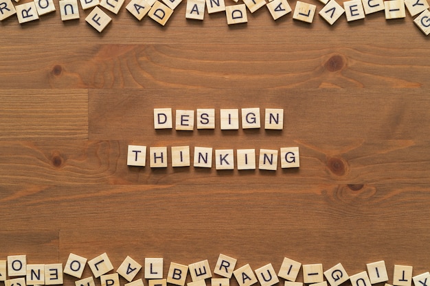 "Design thinking" woordtekst schreef met houten letters geïsoleerd op houten bureau