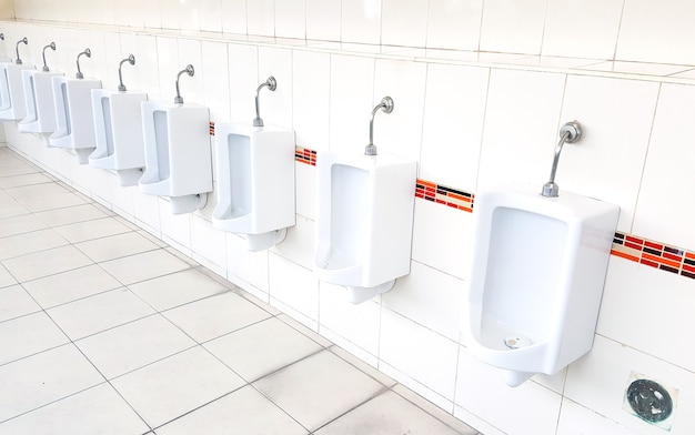 Photo design of white ceramic urinals for men in public toilet room