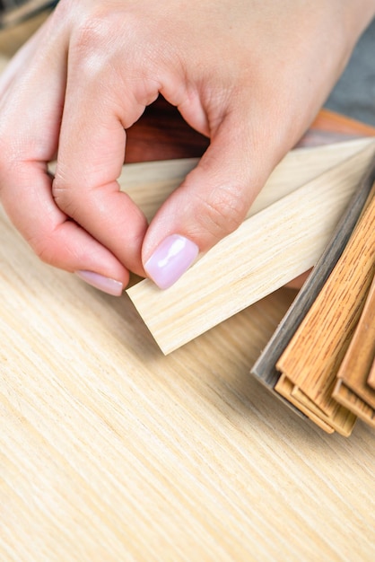 The designer chooses samples of pvc edging for the production of kitchen furniture from lmdp closeup woman's hands hold samples of various colors of pvc edging copy space high quality photo