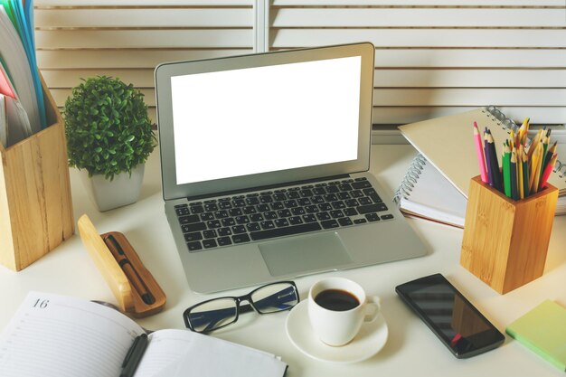 Designer desk with empty white laptop