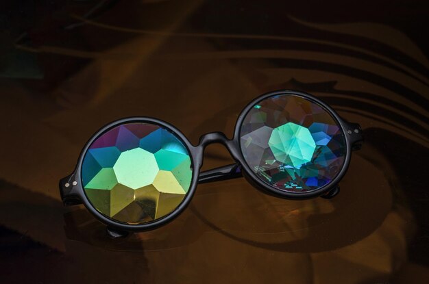 Фото Дизайнерские очки с калейдоскопными очками на стеклянном столе