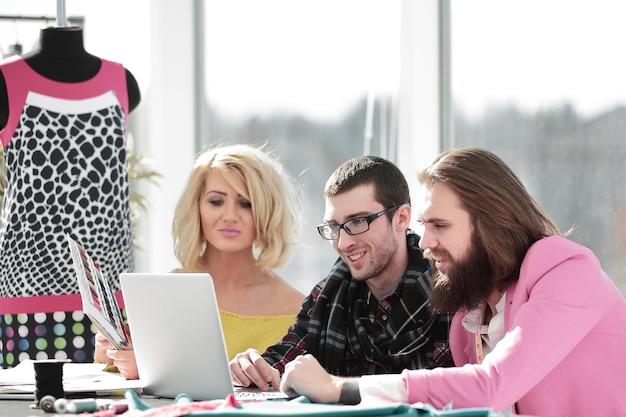 Designer group works on a laptop in a creative office