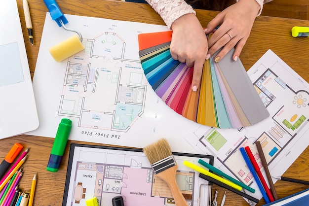 Photo designer hands choosing colour on swatch, close up