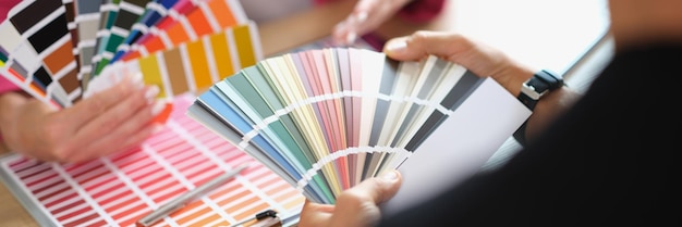 Designer helps client choose colors for project from variety buyer and seller agree on product