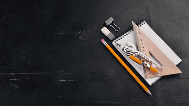 Foto designer matita notebook righello vista dall'alto su sfondo nero spazio libero per il testo