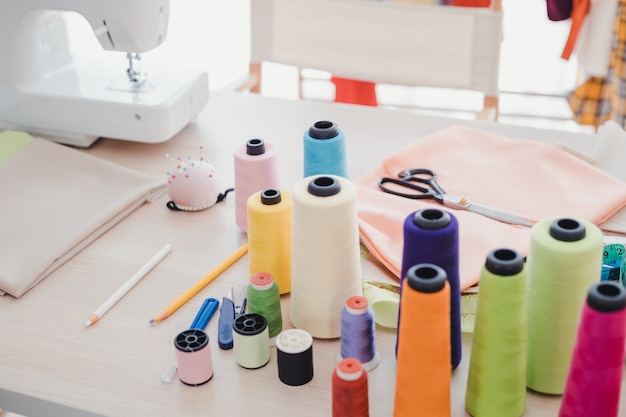On the designer's desk, there are many accessories used to sew.
