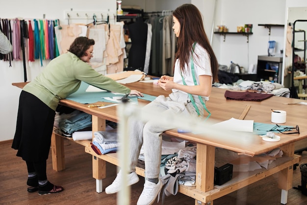 Designer and seamstress in the manufacturing process of clothing in the workshop