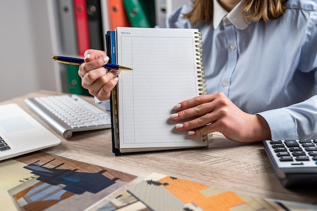 designer woman working blueprint architectural project and tools at office desk