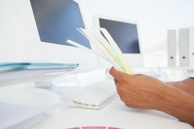 Designer working at desk holding colour samples