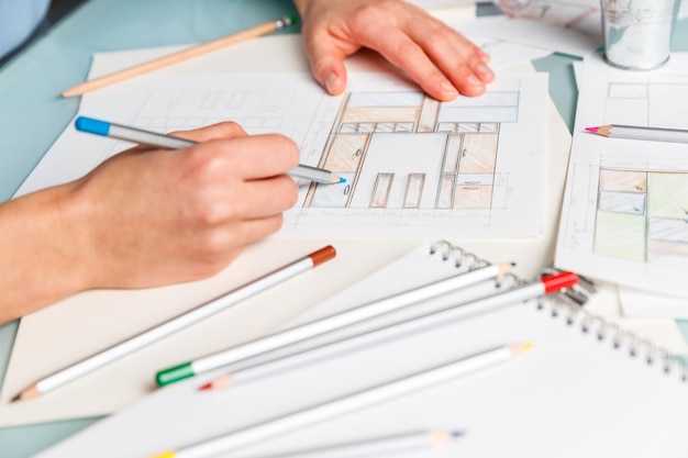 Designer works on color pencil drawing of a furniture