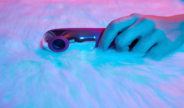 Desire concept Woman lying in bed holding a dildo vibrator in her hand to help herself