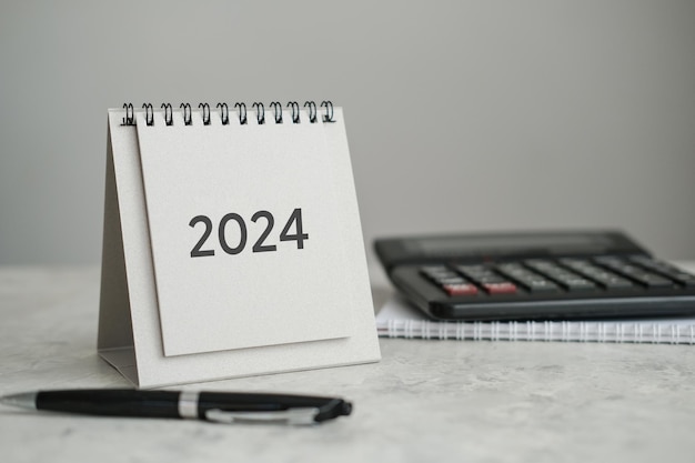 Desk calendar 2024 calculator and pen on the table