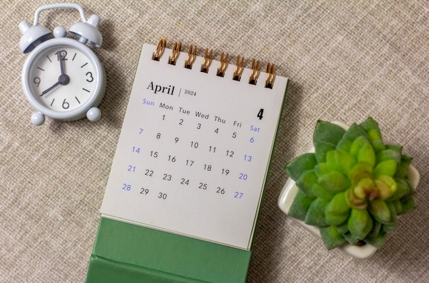 Desk calendar for april 2024 and a clock on the table