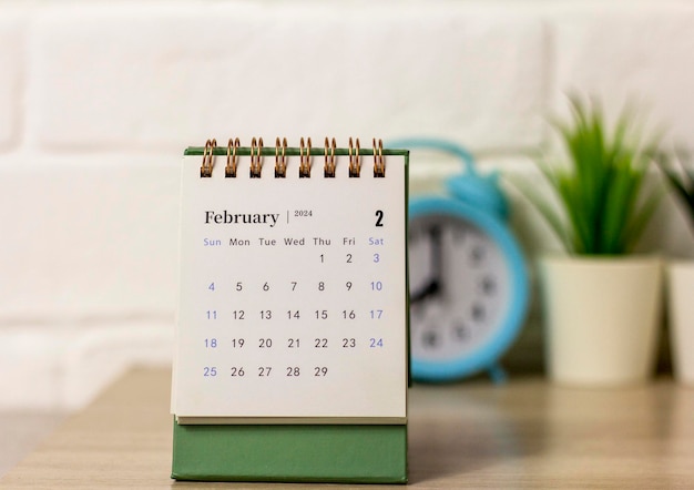 Desk calendar for February 2024 and on the table with copy space