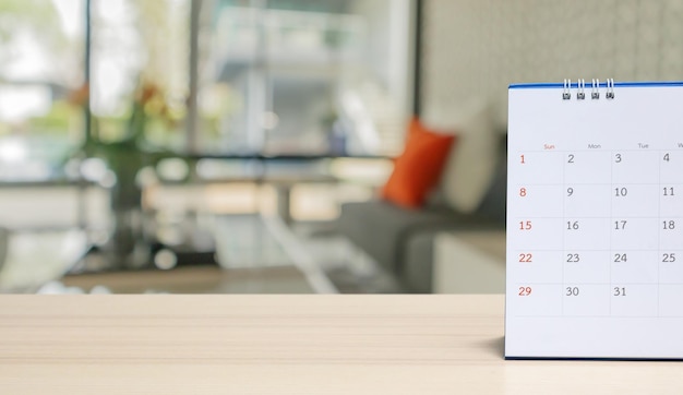 desk calendar on wood table with blurred bokeh background appointment and business meeting concept