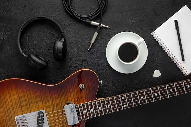 Desk of musician for songwriter work set with headphones and guitar