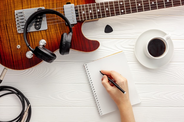 Photo desk of musician for songwriter work set with headphones and guitar