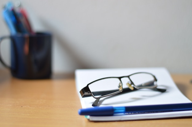 Desk organizer, Work desktop, eyeglasses, accessories, stationery,on a wooden table.