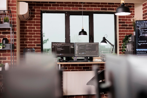 desk table with multiple monitors running terminal window and artificial intelligence programming database script. empty it programming agency office with servers cloud computing. coding concept