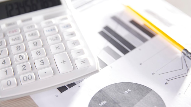 Foto scrivania con calcolatrici per il calcolo, la gestione e l'analisi dei profitti e delle perdite economiche