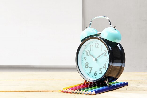 Photo desk with clock and row of colored pencils