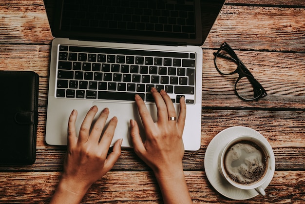 desk with laptop, glasses and a cup of coffee