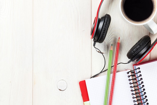 Desk with notepad coffee and headphones