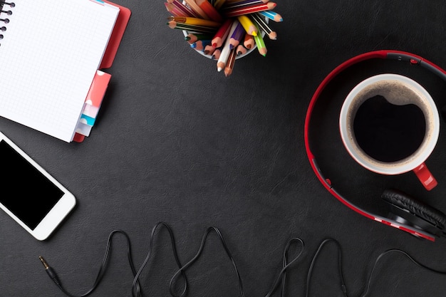 Desk with notepad coffee smartphone and headphones