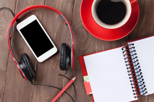 Desk with notepad coffee smartphone and headphones