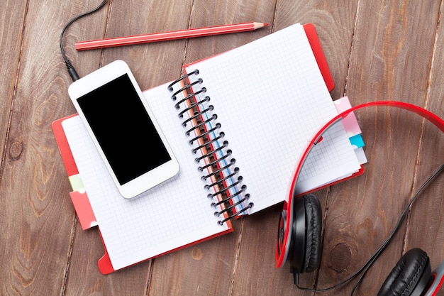 Desk with notepad smartphone and headphones