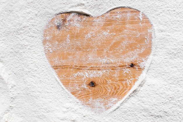 Desk of wood with mark of heart in flour