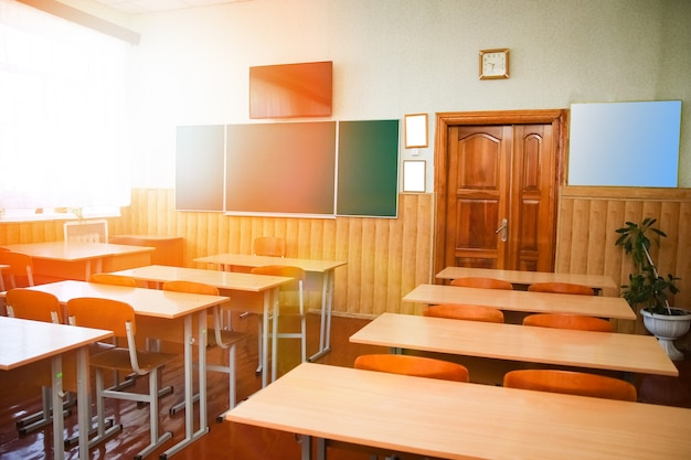 A Desks desks in the classroom on the background of the school blackboard background