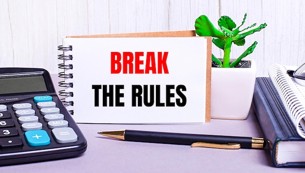 바탕 화면에는 BREAK THE RULES Business concept Workplace close라는 텍스트가 있는 노트북과 화분에 심은 계산기 일기가 있습니다.