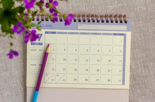 Desktop calendar for July 2023 on the table with a space to copy