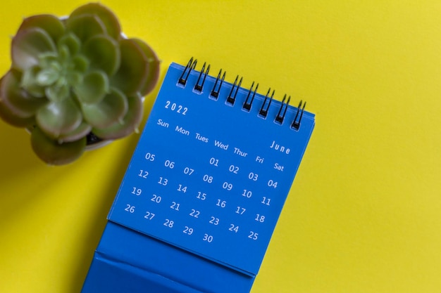 Desktop calendar for June 2022 on a yellow background