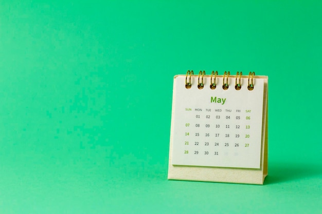 Desktop calendar for May 2023 on a green background