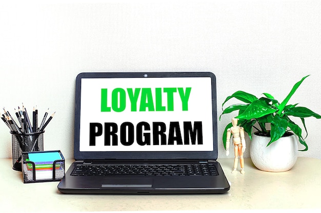 바탕 화면에는 화분에 심은 문구류와 화면 홈 오피스에 LOYALTY PROGRAM이라는 텍스트가 있는 열린 노트북이 있습니다.