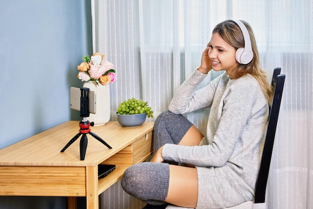 Desktop tripod with phone holder for female streamer in headphones inside