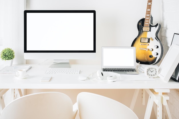 Desktop with blank devices and guitar