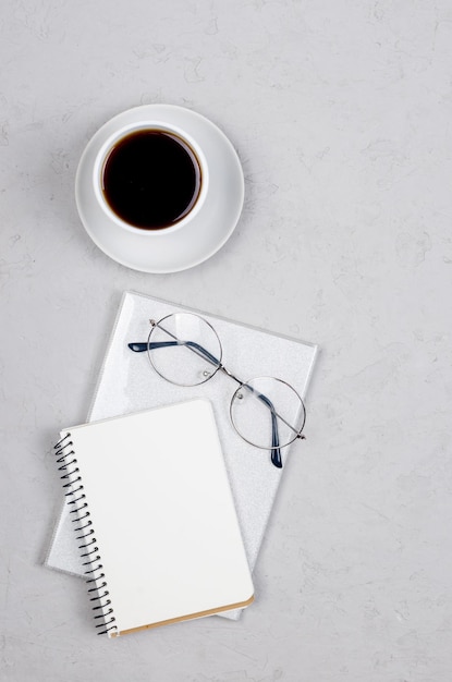 Desktop with blank notebooks pens glasses and coffee