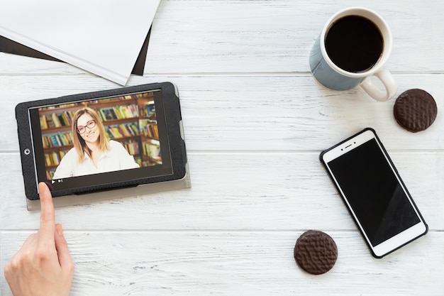 Desktop with tablet, phone, coffee and cookies, flat lay. Online school, virtual education